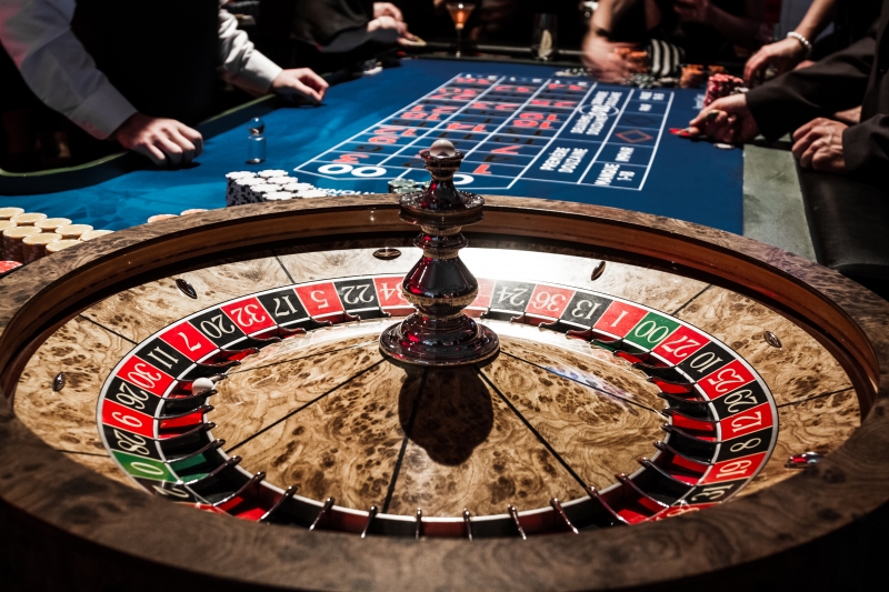 8823097-wooden-shiny-roulette-details-in-a-casino-and-people